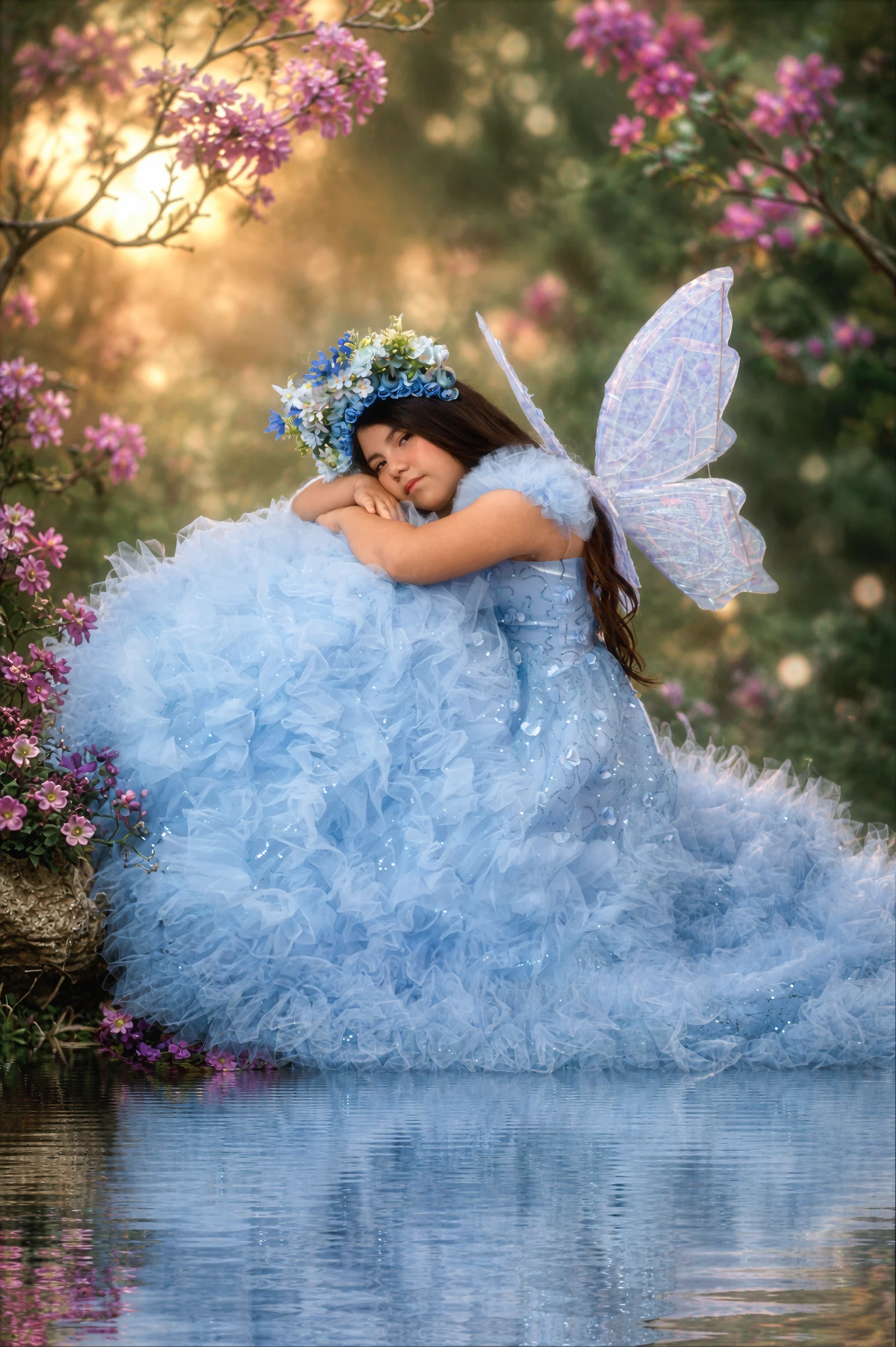 Renata entre flores, con sus alas y vestido azul de cuento
